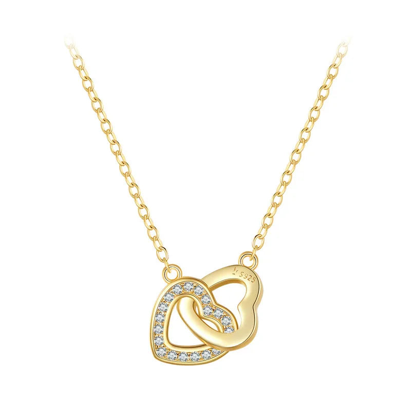 Gold-tone interlocking heart necklace with a clear CZ stone row on a white background