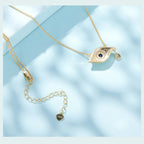 Back view of the gold-tone eye necklace showing the extender chain, clasp, pendant reverse, and S925 tag