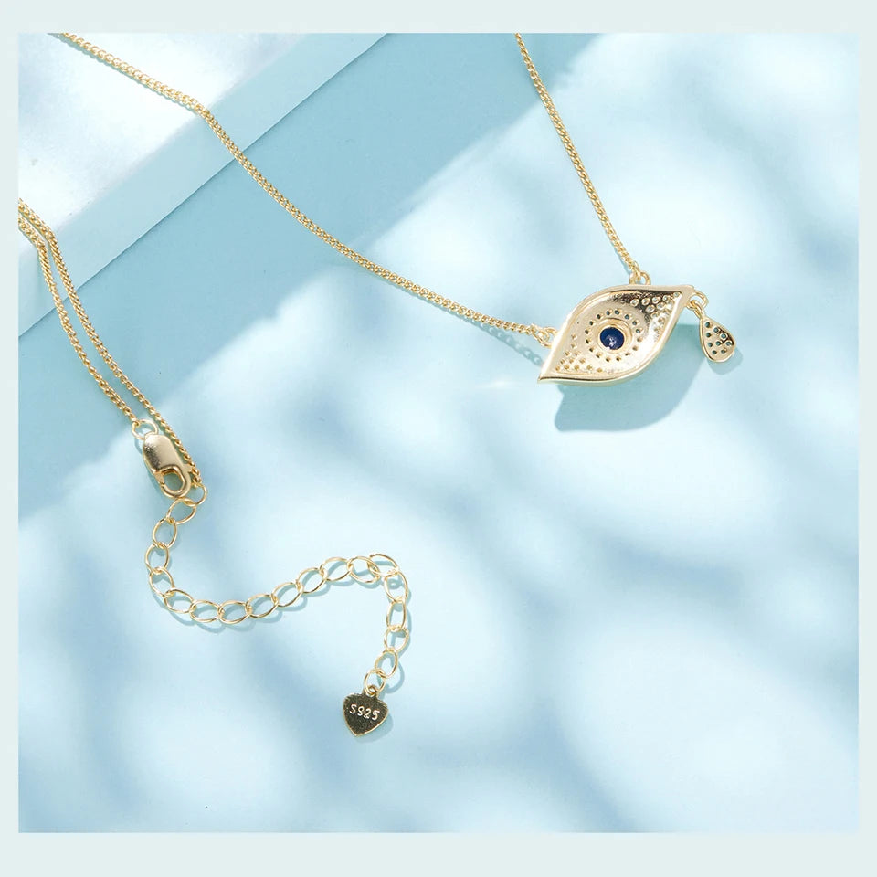 Back view of the gold-tone eye necklace showing the extender chain, clasp, pendant reverse, and S925 tag