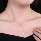 Gold-tone rosary drop necklace worn on the neck with a round stone-set center and hanging cross