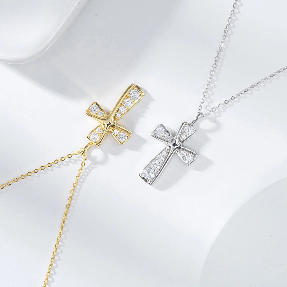Gold-tone and silver-tone curved cross necklaces with clear CZ stones on a white surface