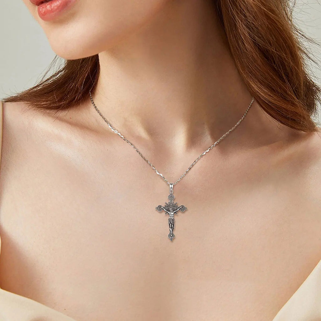 Gothic silver crucifix worn on the neck, showing the detailed figure of Jesus and floral arm ends