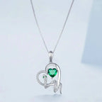 Close view of the coiled snake pendant with green heart cubic zirconia and clear stone details