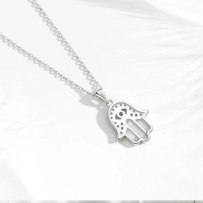 Back view of the sterling silver hamsa pendant showing the openwork hand and blue eye setting