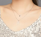 Two-chain sterling silver necklace worn on the neck with a heart pendant above a stone-set cross