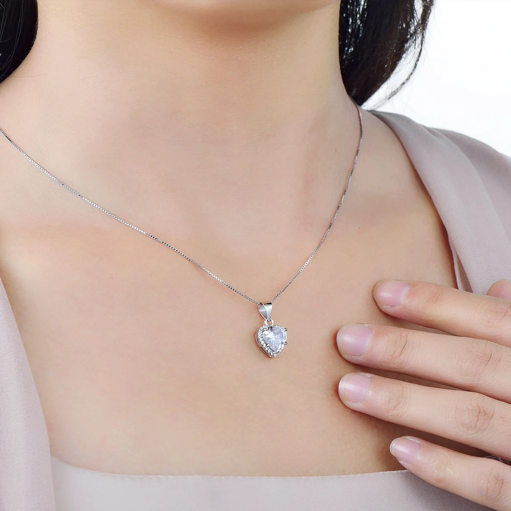 Sterling silver heart halo necklace worn at the collarbone with a clear cubic zirconia center