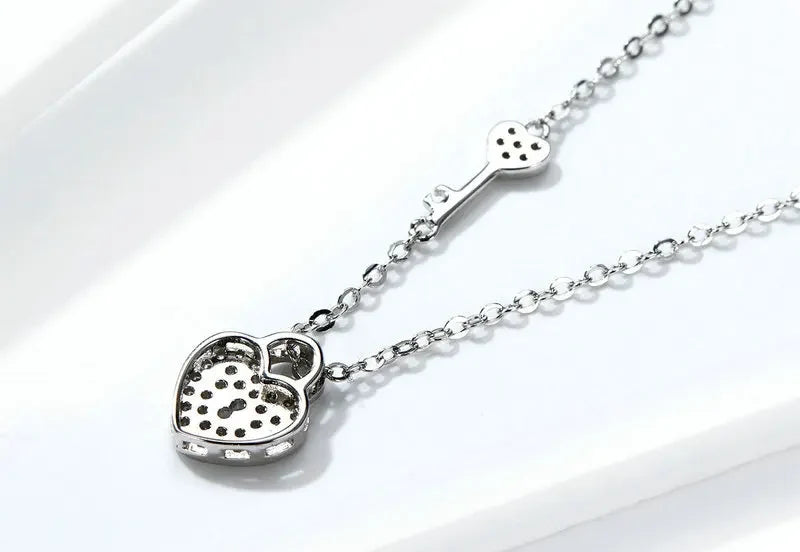 Rear view of the heart lock and key necklace showing open settings behind the stones