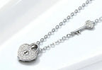 Platinum-plated sterling silver heart lock necklace laid across a white display block