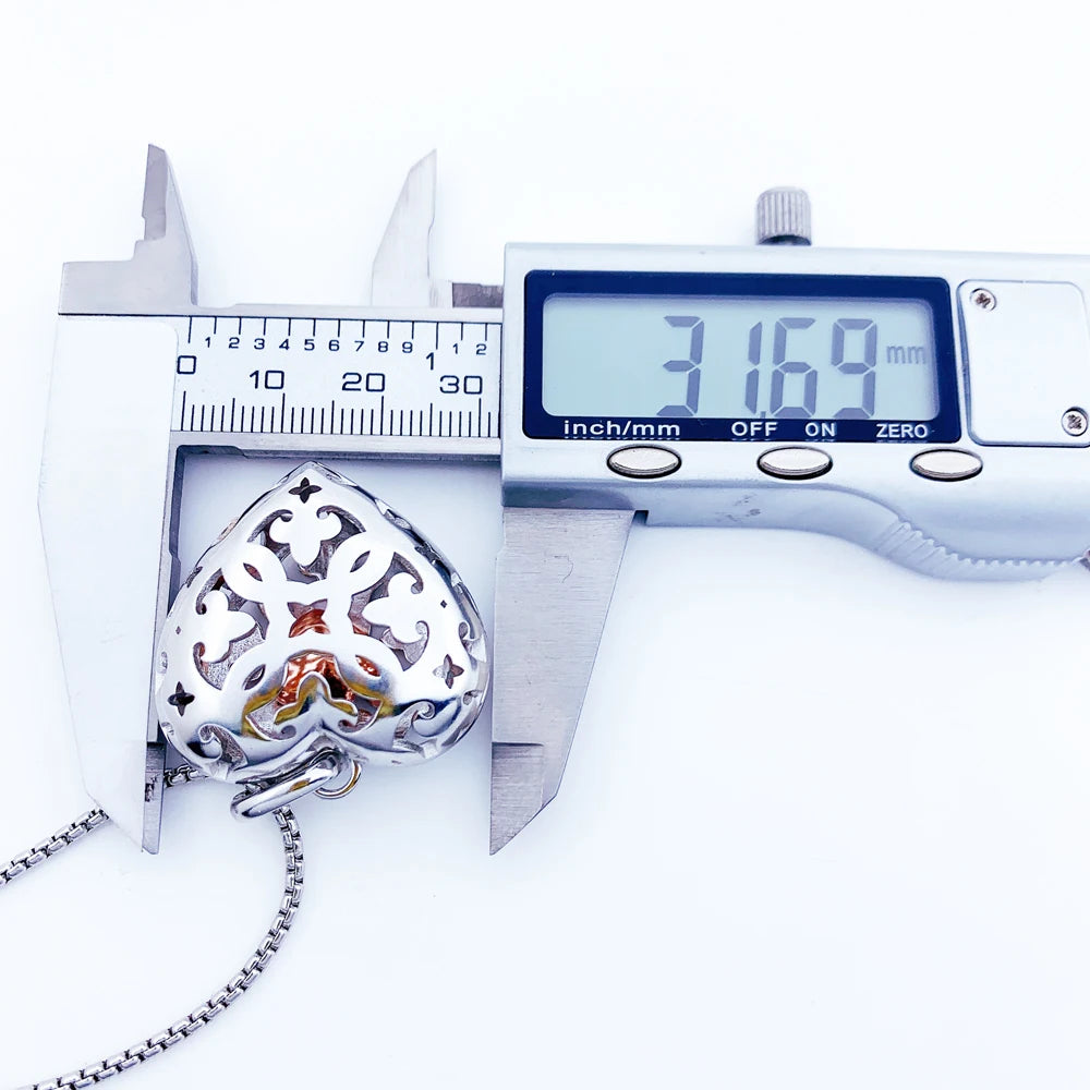 Caliper measuring the openwork heart locket width at 1.25 in (3.2 cm)