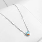 Close view of the sterling silver heart necklace with pale blue enamel and three-prong multicolored CZ setting