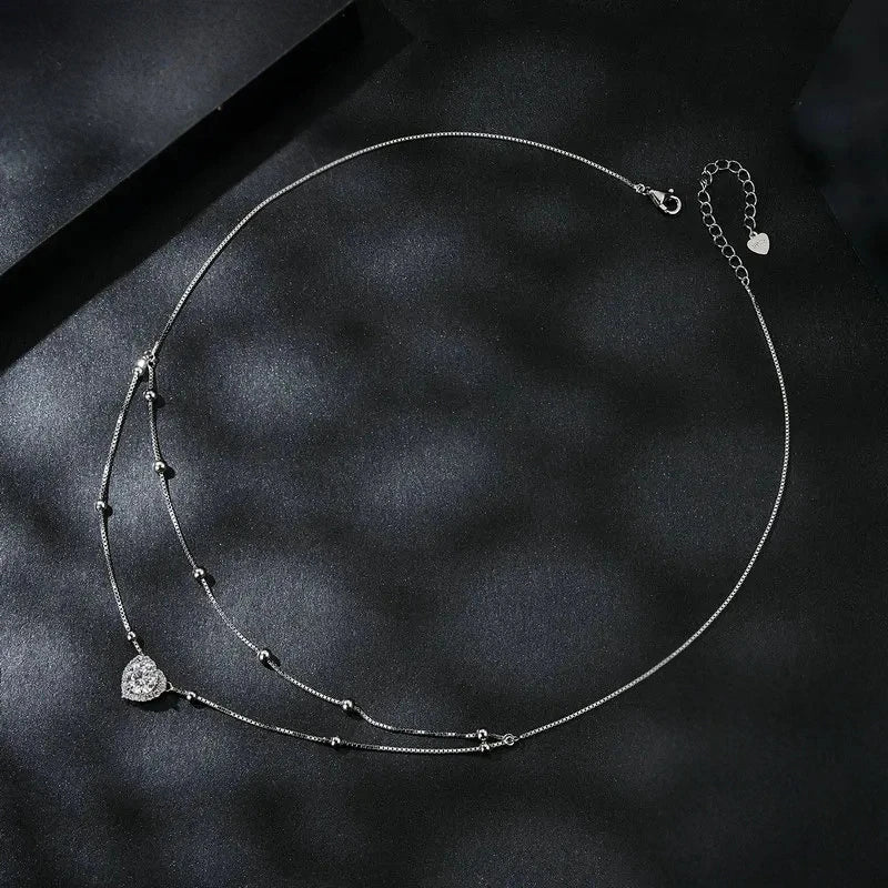 Full layered heart necklace on black satin showing the extender chain, clasp, bead stations, and heart pendant