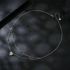 Full layered heart necklace on black satin showing the extender chain, clasp, bead stations, and heart pendant