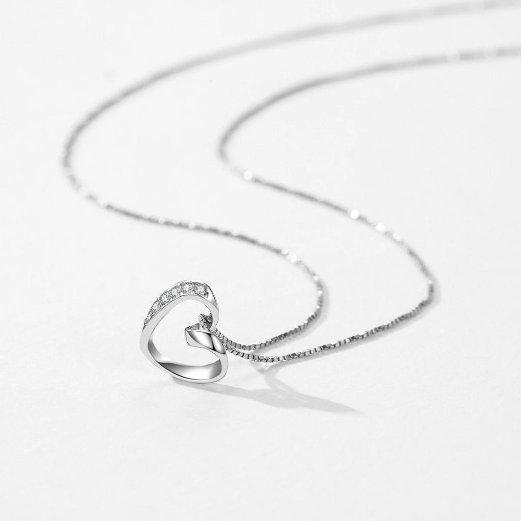 Sterling silver open heart pendant lying flat with a CZ stone curve and box-link chain