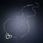 Full sterling silver necklace laid out on a dark surface, showing the box chain and heart pendant