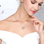 Close view of a woman wearing the two-tone heart necklace centered below the collarbone