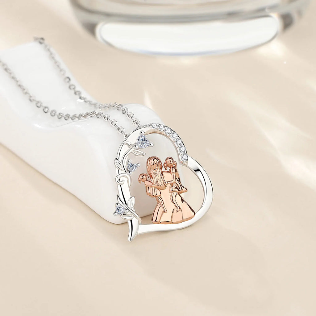 Sterling silver heart pendant resting on a white display block with rose-gold-colored mother and daughters