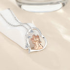 Sterling silver heart pendant resting on a white display block with rose-gold-colored mother and daughters