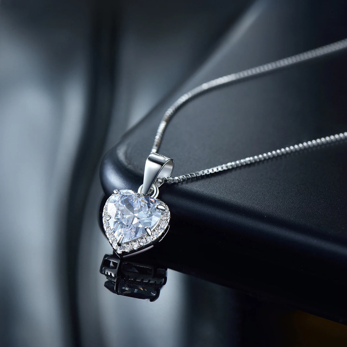 Side view of the sterling silver heart necklace showing the polished bail and box-link chain