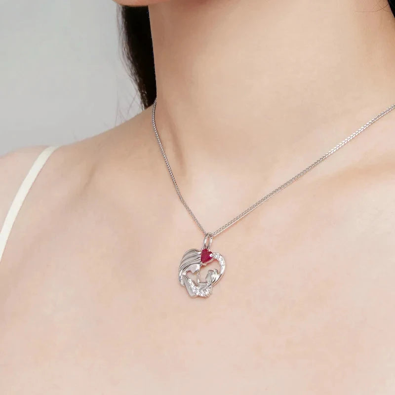 Mother and child heart necklace worn at the collarbone with a red heart stone and clear CZ accents