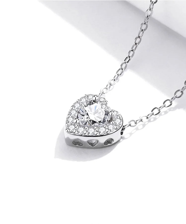 Close-up of the heart pendant with raised center stone and tiny heart cutouts along the side