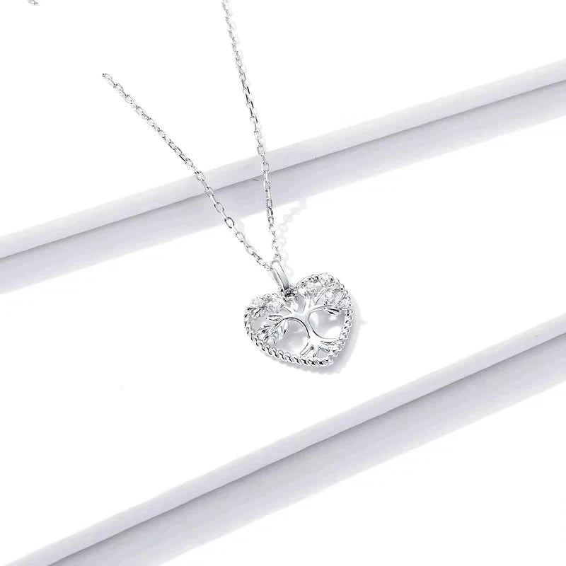 Platinum-plated sterling silver heart tree necklace displayed on a white surface with a rope-textured edge