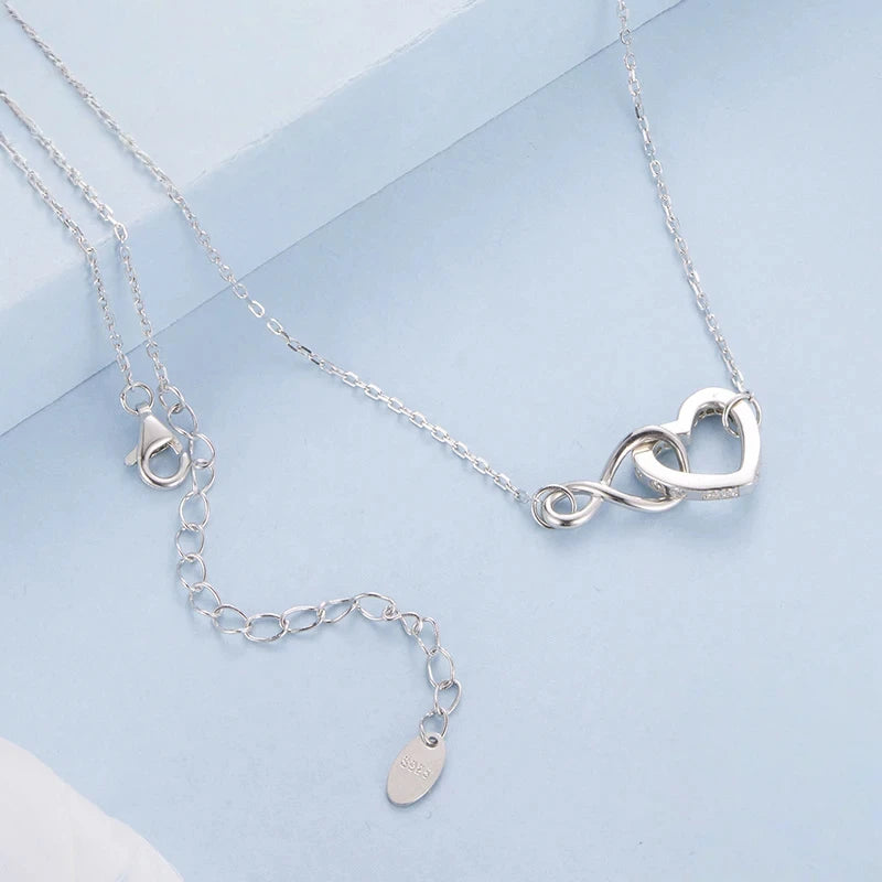 Close view of the infinity heart pendant, link chain, lobster clasp and extension chain
