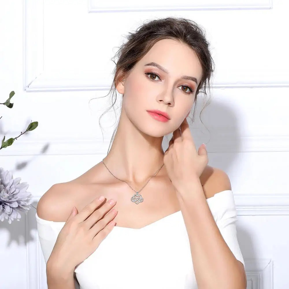 925 sterling silver infinity knot heart necklace worn at the collarbone with an off-shoulder top