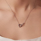 White gold-plated sterling silver infinity open heart necklace worn at the base of the neck