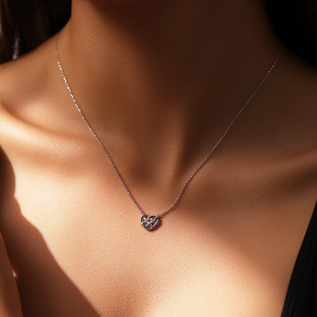 Interlaced heart pendant necklace worn on the neck, showing the central line of moissanite stones