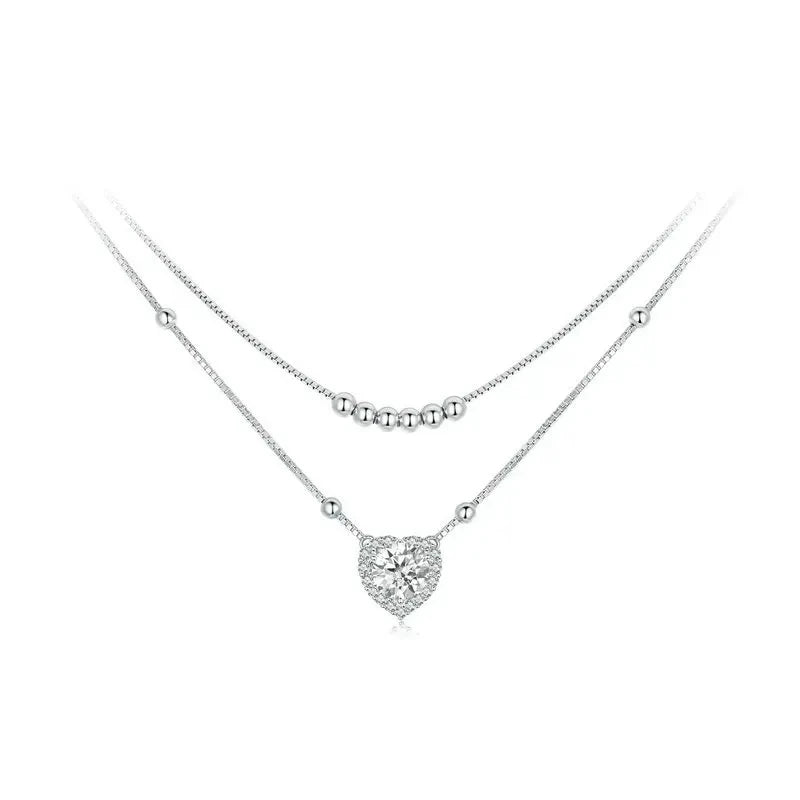 Layered heart necklace in 925 sterling silver with bead strands and a moissanite heart on white
