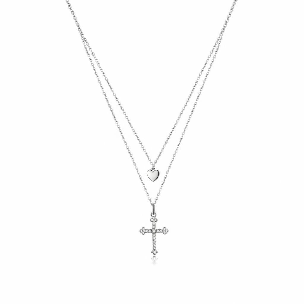 Layered Silver Cross Necklace with Heart Pendant on a plain white background