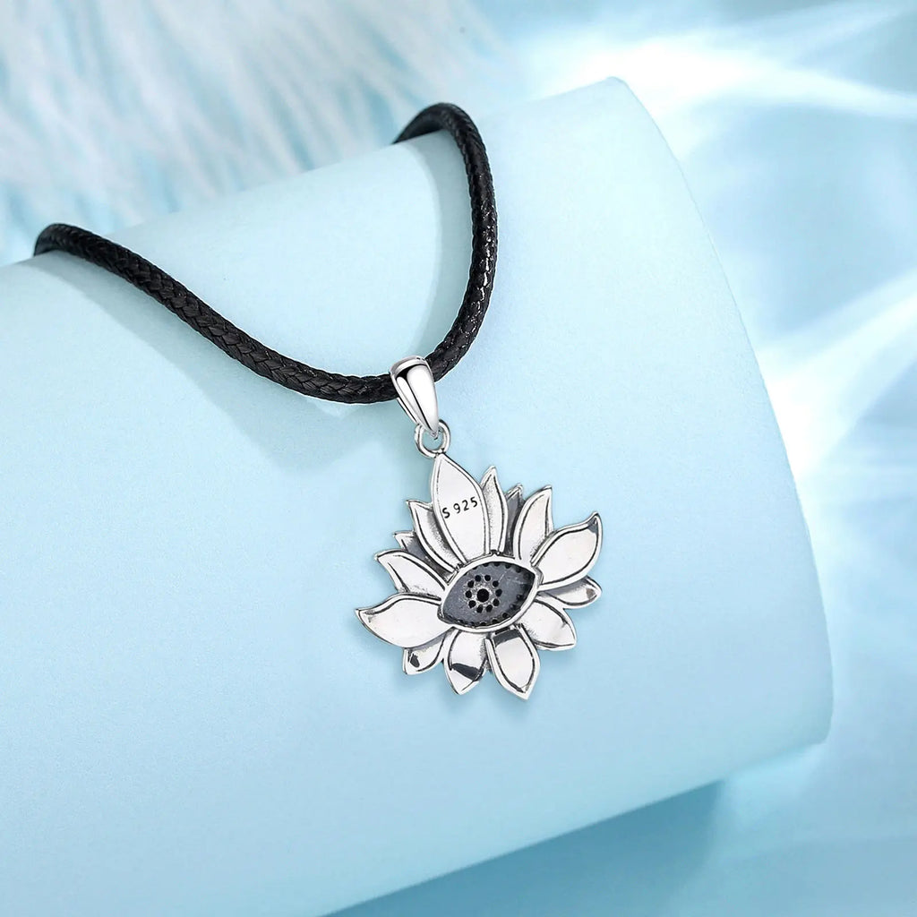 Back of the lotus pendant on a black braided rope, showing the S925 stamp and open stone setting