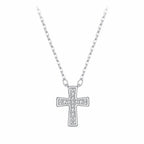 Minimalist silver cross necklace with moissanite stones on an oval-link chain against white