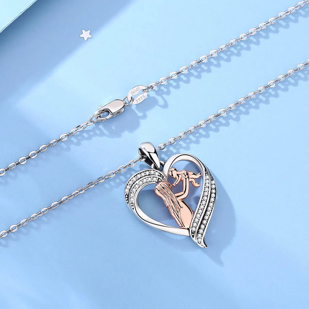 Mother and baby heart necklace laid on a blue surface with oval-link chain and lobster clasp