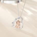Mother and two daughters heart pendant hanging from an oval-link chain against a softly lit background