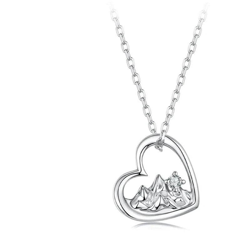 White gold-plated 925 sterling silver heart pendant with raised mountain peaks and a round CZ stone