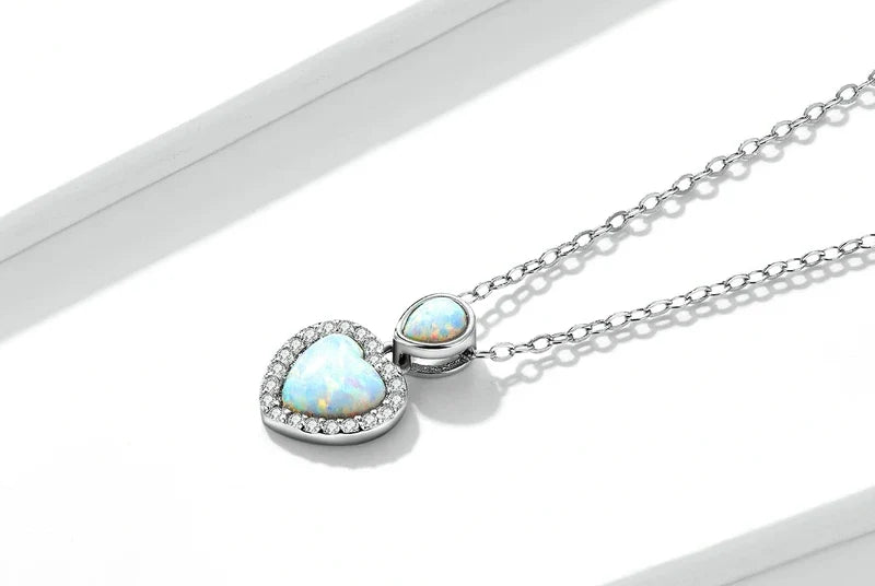Pale-blue opal-look heart pendant with a pear-shaped blue stone on a fine oval-link chain
