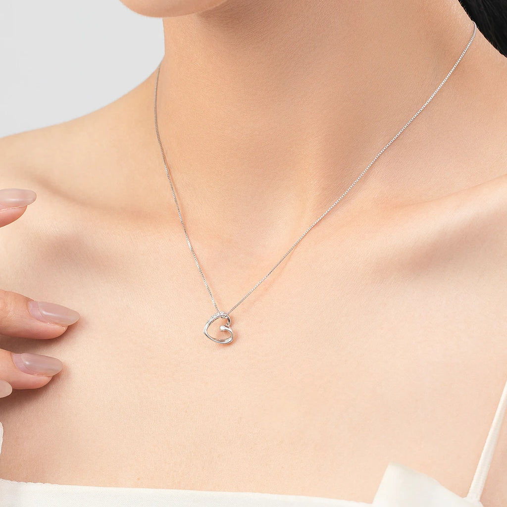Open heart necklace worn at the collarbone, with a stone-set upper curve