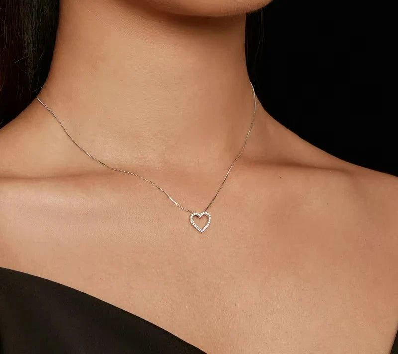 Moissanite open heart necklace worn at the base of the neck with a silver-colored box chain