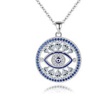Openwork evil eye necklace with blue and clear cubic zirconia around a round eye pendant on white