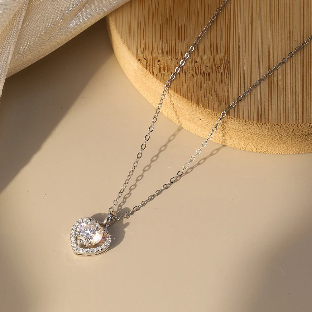 Oval-link chain with heart halo pendant arranged beside a wooden display and fabric
