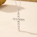 Close-up of the simulated pearl cross pendant with textured beaded silver rims