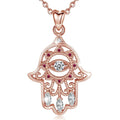 Pink stone hamsa hand necklace with an evil eye center, pink CZ stones and three clear marquise stones on white