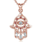 Pink stone hamsa hand necklace with an evil eye center, pink CZ stones and three clear marquise stones on white