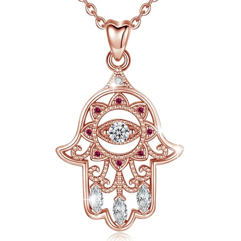 Pink stone hamsa hand necklace with an evil eye center, pink CZ stones and three clear marquise stones on white