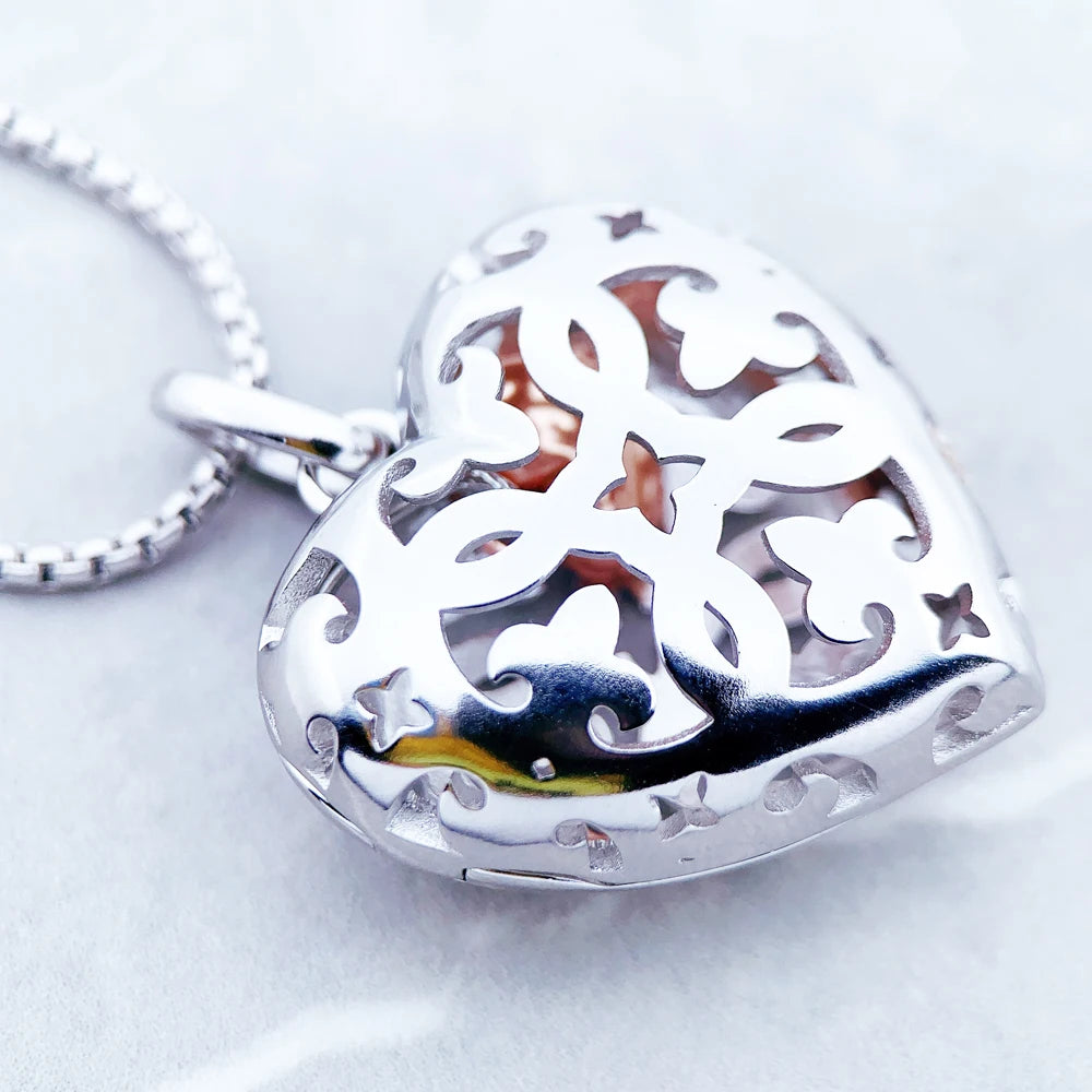 Close-up of the polished sterling silver heart locket with pierced scrolls and quatrefoil openings