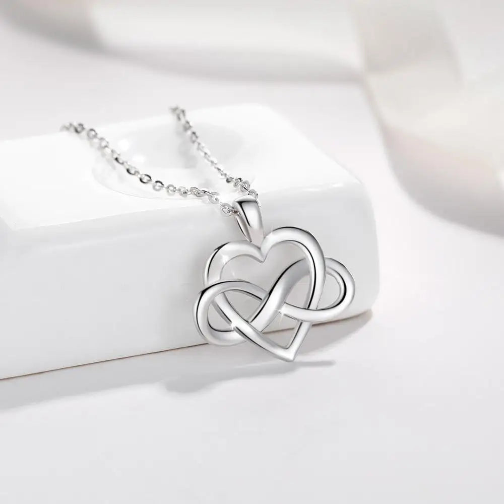 Close-up of a polished 925 sterling silver open heart pendant woven with a sideways infinity loop