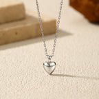 Close-up of the polished sterling silver puffy heart pendant on an elongated-link chain