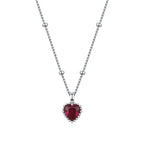 Close-up of the red CZ heart necklace with a scalloped beaded silver-tone frame