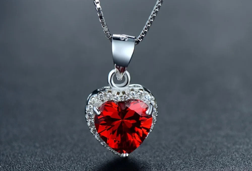 Front close-up of the faceted red CZ heart pendant with a clear CZ halo and polished bail